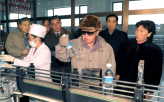 Kim Jong-il Studies a Bottle of Water                                                               